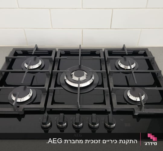 כיריים גז שחורות עם חמישה מבערים וכפתורי שליטה